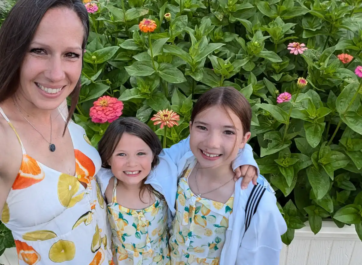 Kate, Olivia, and Natalie pose in lemon dresses in the zinnia garden